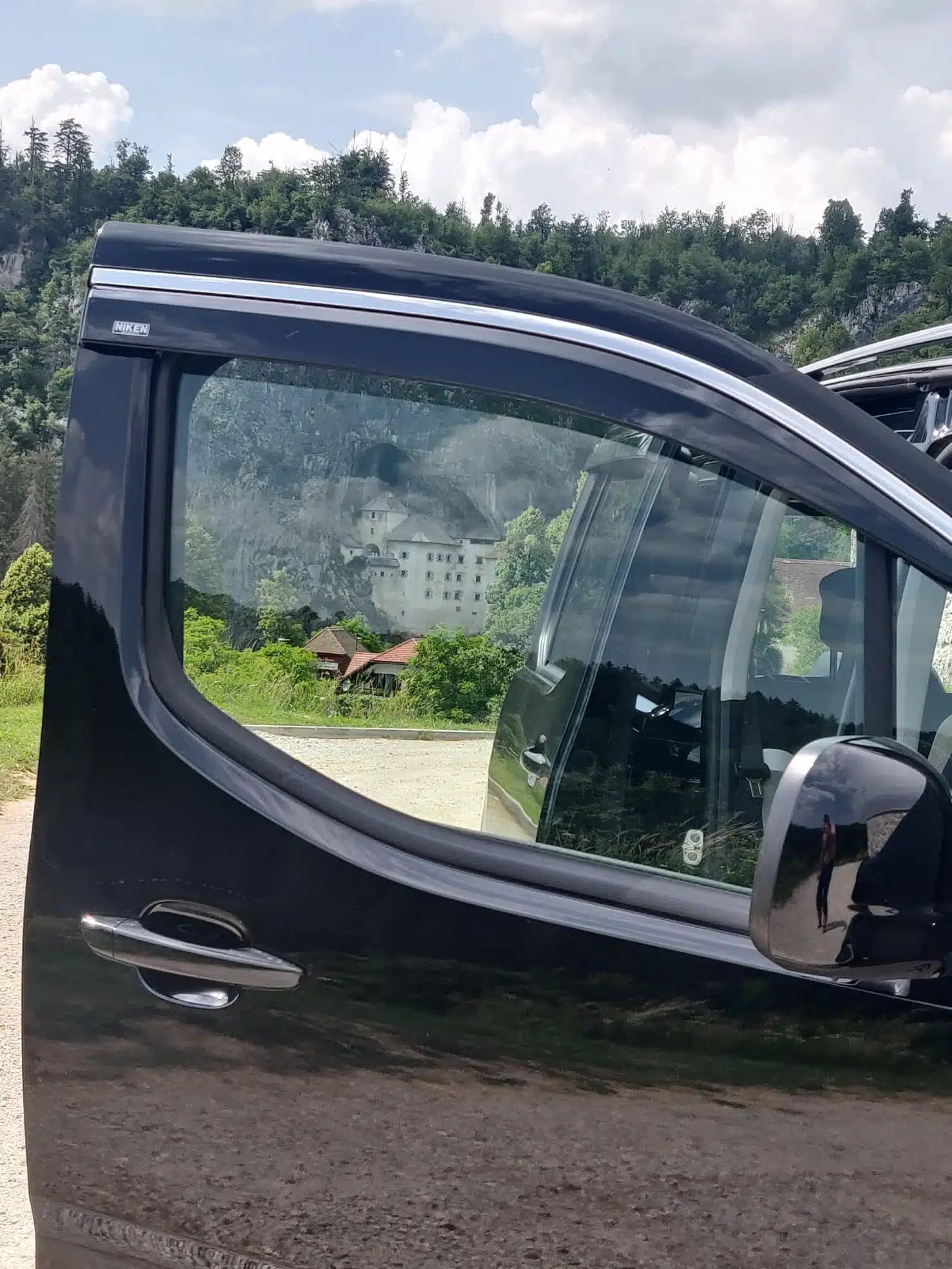 The front door of Citroen Berlingo for your private day trips, facing the Postojna Predjama Castle from a far.